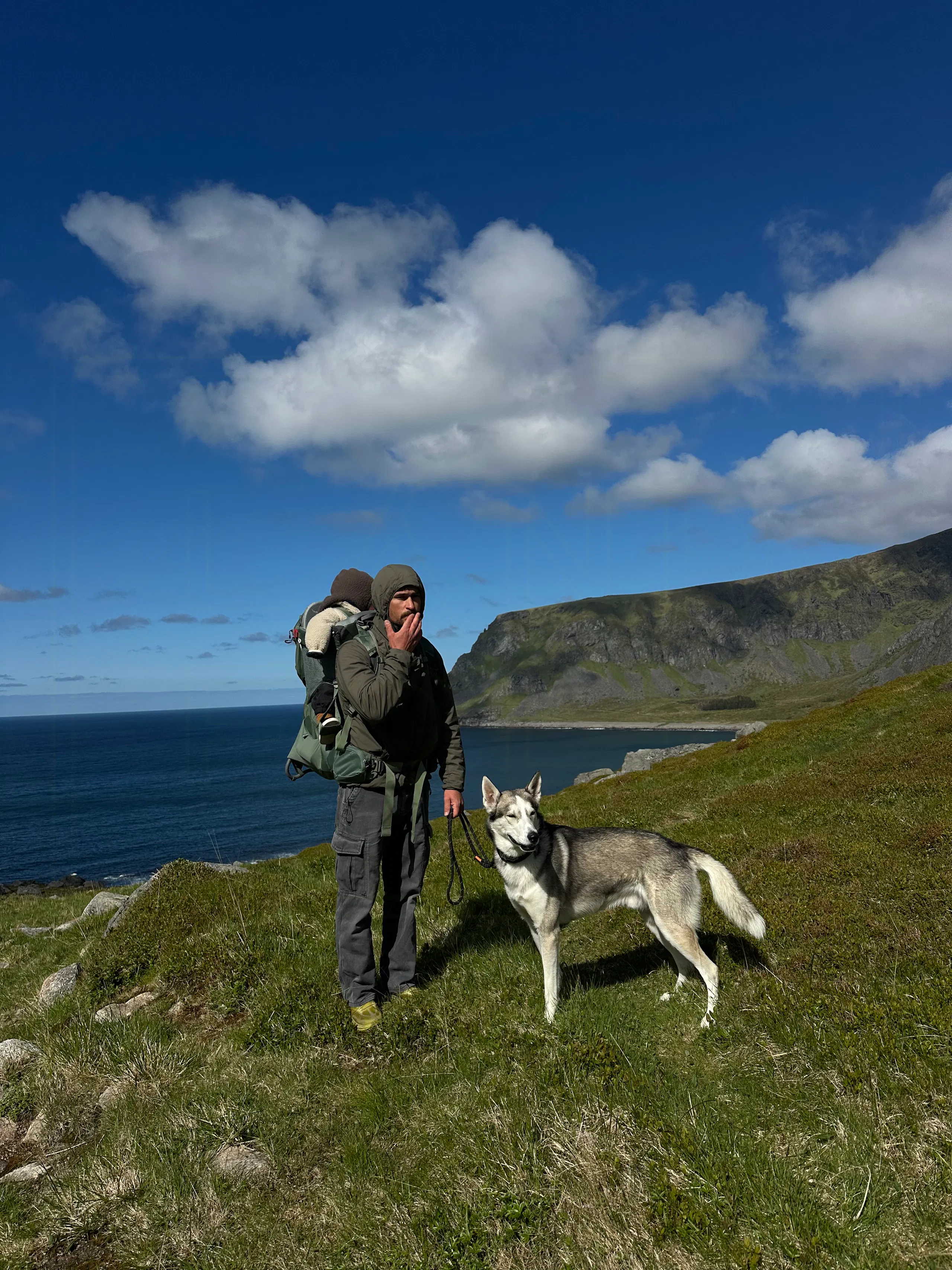 Agnes hiking with a dog in the hills near Unstad in Lofoten