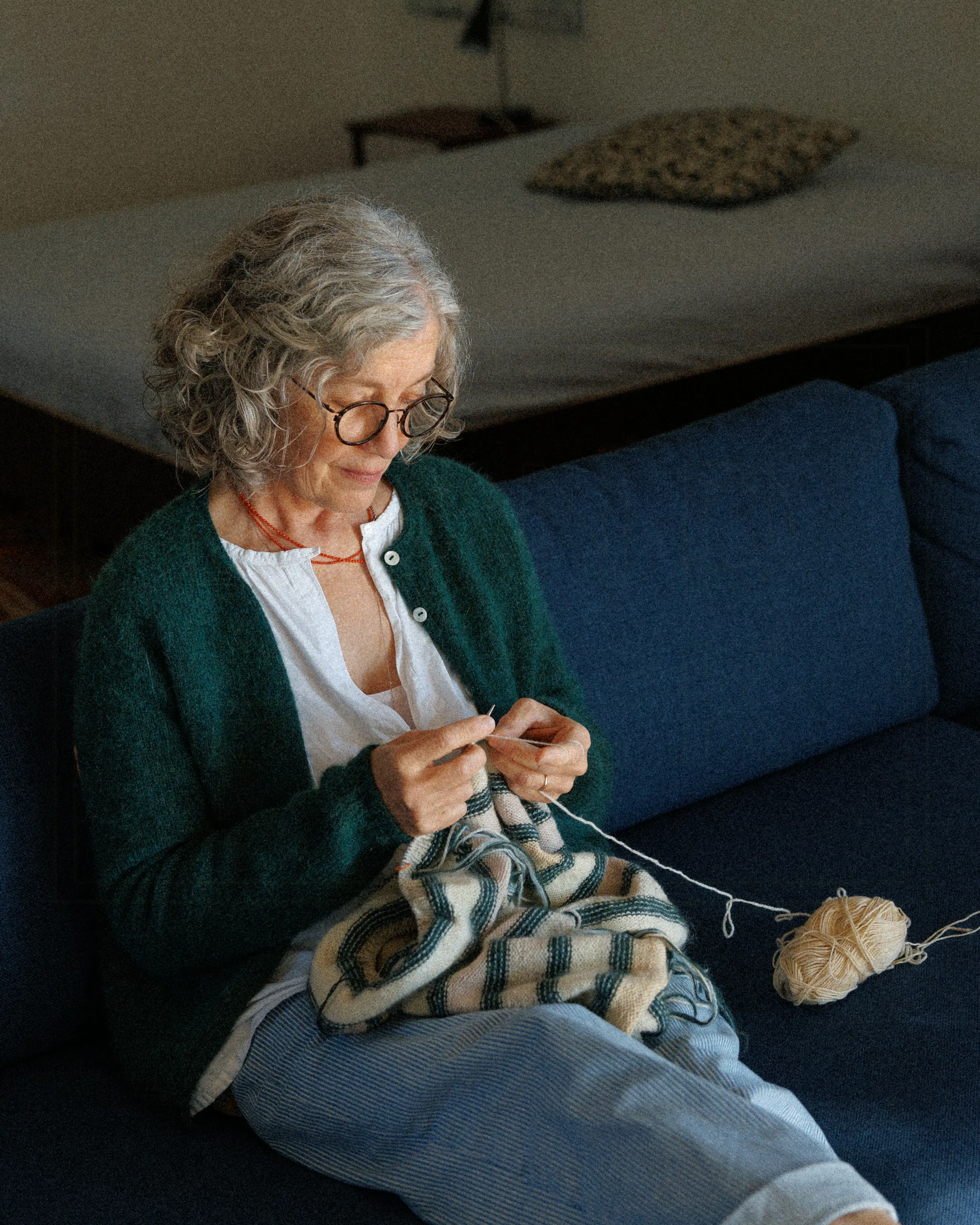 Patricia knitting on the sofa